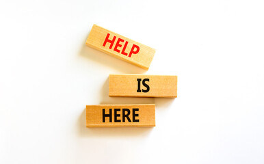 Wall Mural - Help is here and support symbol. Concept words Help is here on wooden blocks on beautiful white table white background. Business, support, help is here concept. Copy space.