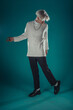 © qunica.com - Male beauty concept. Portrait of fashionable young man with stylish haircut wearing trendy glasses and sweater, posing over gray background. Perfect hair & skin. Hipster style. Copy-space. Studio shot