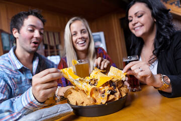 Group of friends having natchos in the bar