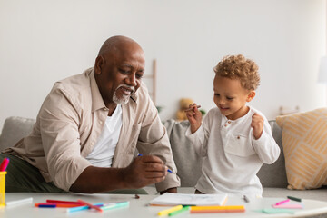 Wall Mural - Happy Black Little Boy And Grandpa Drawing Picture At Home