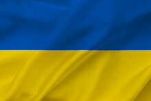 Ukraine Flag On Waving Silk Background. National Flag With Yellow And Blue Colors. Fabric Texture.