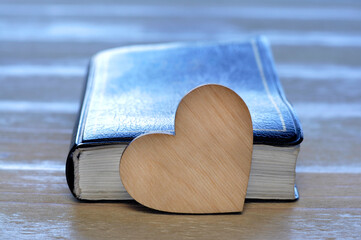 Wall Mural - Bible open. Heart on the book. Love concept. Holy Scripture. On a wooden table.