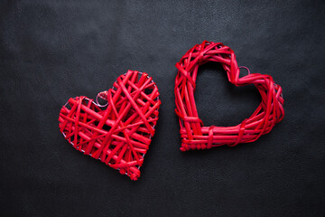 Wall Mural - Two red wicker hearts on a black background. Valentine's day concept for your design