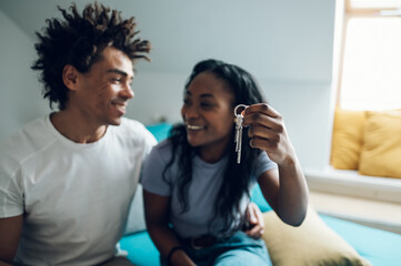 African american couple holding home keys in their new apartment