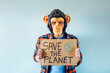 © karrastock - Man with monkey mask showing a sign that says SAVE THE PLANET.