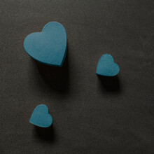 Three Blue Heart Shapes On A Black Background From Above