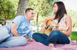 © Andy Dean - Young Adult Girl Playing Guitar with Boyfriend In The Park.