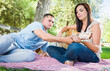 © Andy Dean - Young Adult Man Teaching Girlfriend How To Play The Guitar Outside in the Park.
