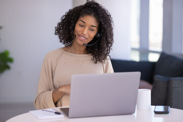 Sticker - Young black woman at home remote working on laptop computer talking to her colleague