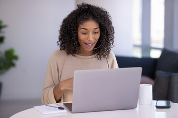 Poster - Young black woman at home remote working on laptop computer talking to her colleague