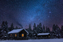 A Beautiful Snowy Cabin In The Winter Mountains Of Montana With Stars At Night