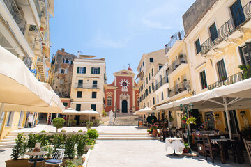 Wall Mural - Corfu town beautiful street with cafe and flowers, Corfu island, Ionian islands, Greece. Picturesque landmark of Kerkyra old town.