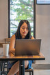 © Quang - Young woman focus on working with laptop at coffee shop