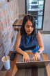 © Quang - High angle view of woman using laptop at rustic cafe