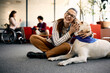 Happy businesswoman embraces her Labrador therapy dog and having fun in office.
