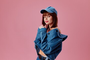 Wall Mural - Portrait of a charming lady in a cap and denim jacket posing color background unaltered