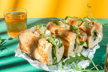 Wall Mural - Sandwich with chicken, cucumber and arugula on a green background