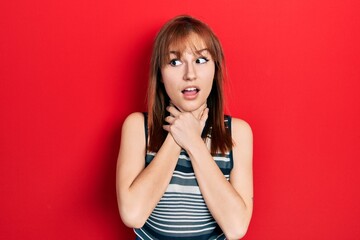 redhead young woman wearing casual t shirt shouting and suffocate because painful strangle. health p