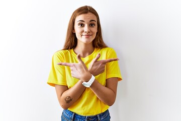 Sticker - Young brunette woman standing over isolated background pointing to both sides with fingers, different direction disagree