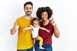 © Krakenimages.com - Interracial young family of black mother and hispanic father with daughter doing happy thumbs up gesture with hand. approving expression looking at the camera showing success.