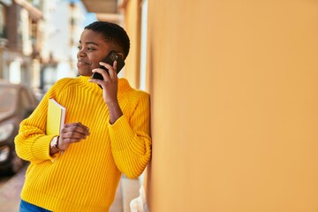 Poster - Young african american woman smiling happy talking on the smartphone at the city