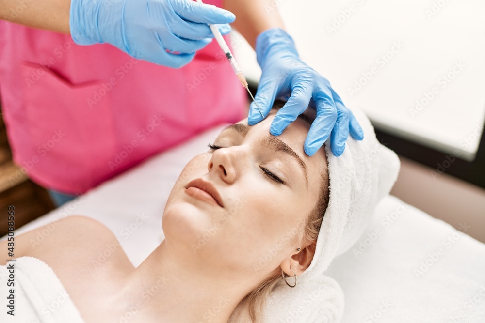 Doctor injecting botox on woman face for anti aging treatment at the clinic.