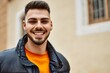 © Krakenimages.com - Handsome hispanic man with beard smiling happy and confident at the city wearing winter coat