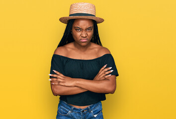 Sticker - Young african american woman wearing summer hat skeptic and nervous, disapproving expression on face with crossed arms. negative person.