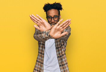 Sticker - Young african american man with beard wearing casual clothes and glasses rejection expression crossing arms and palms doing negative sign, angry face