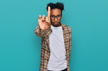 Young african american man with beard wearing casual clothes and glasses pointing with finger up and angry expression, showing no gesture