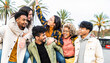 © Davide Angelini - Multiracial group of friends bonding outside - Happy young people walking down the street laughing and having fun - Adult students hangout together in the city center - Friendship lifestyle concept