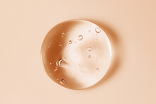 Cosmetic Serum Gel Beauty Oil Drop On Color Background. Skin Care Product Droplet With Bubbles Texture Macro