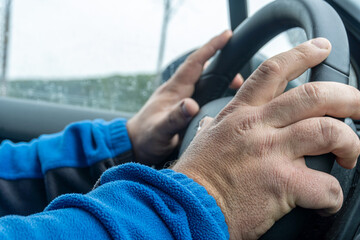 Close-up of male photos on the steering wheel of a car.