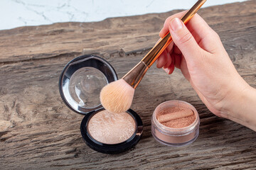 Canvas Print - Beautiful woman’s hands holds cosmetic mineral blush and makeup brush. Women's hands holding the powder and brush. The concept of beauty, the work of a makeup artist.