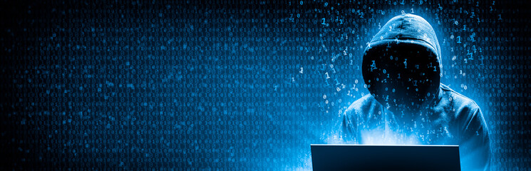 silhouette of hooded criminal hacking computer on binary code background - cyber crime concept