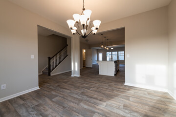 Empty modern townhouse floor showcasing a kitchen with living and dinning room ready to be moved in. Investment, renting, or house ownership concept.