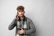 © Tatiana - Attractive man in a plaid scarf talking on the phone posing emotions isolated background