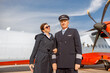© Kostiantyn - Aircraft pilot and stewardess standing arm in arm at airport
