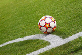 Fototapeta Sport - A soccer ball sits on the pitch near by corner area
