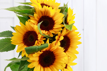 Fotomurales - Bouquet of sunflowers on a white wooden background.