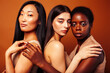 © iordani - young pretty caucasian, african, scandinavian woman posing cheerful together on brown background, lifestyle diverse nationality people concept