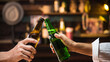 © taveesaksri - two hands hold beer bottle toasting in bar