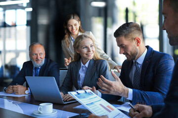 Group of business partners discussing ideas and planning work in office.