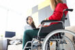 © H_Ko - Woman in wheelchair communicates with friend at home closeup