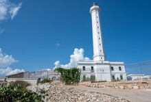 Santa Maria Di Leuca, Puglia, Italy. August2021. The Lighthouse Is Located On The Hill Overlooking The Bay. Colored In A Very Light White And With Green Venetian Blinds On The Windows. Nice Sunny Day.