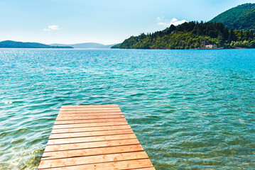 Wall Mural - beautiful scenic landscape with a boat in the bay and a wooden pier near nydri, lefkada, greece. stu