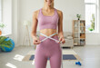 © Studio Romantic - Crop close up portrait of fit sporty slim woman in sportswear measure waist with tape lose weight with diet sport program. Smiling girl show healthy lifestyle result, train exercise and eat healthy.