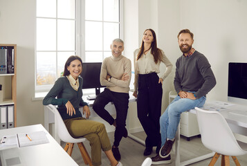 Team of happy young and senior business people in their office. Group portrait of cheerful, positive, smiling corporate employees of different ages in their modern office workplace