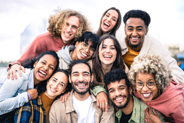 multi ethnic guys and girls taking selfie outdoors with backlight - happy life style friendship conc