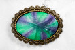 bronze brooch with hand-colored silk batik on gray